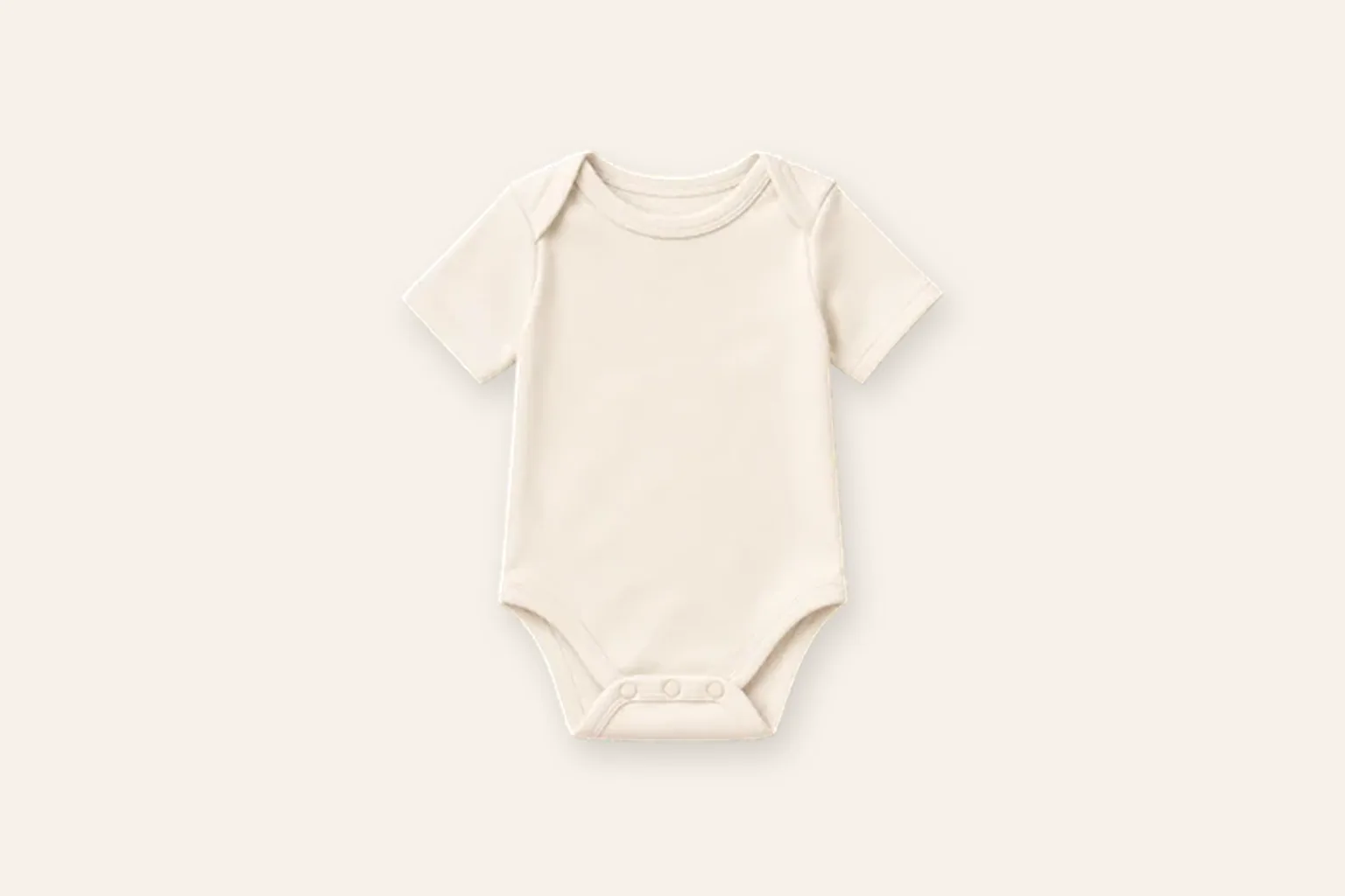 One lightweight short-sleeve baby bodysuit laid alone on an ivory studio background