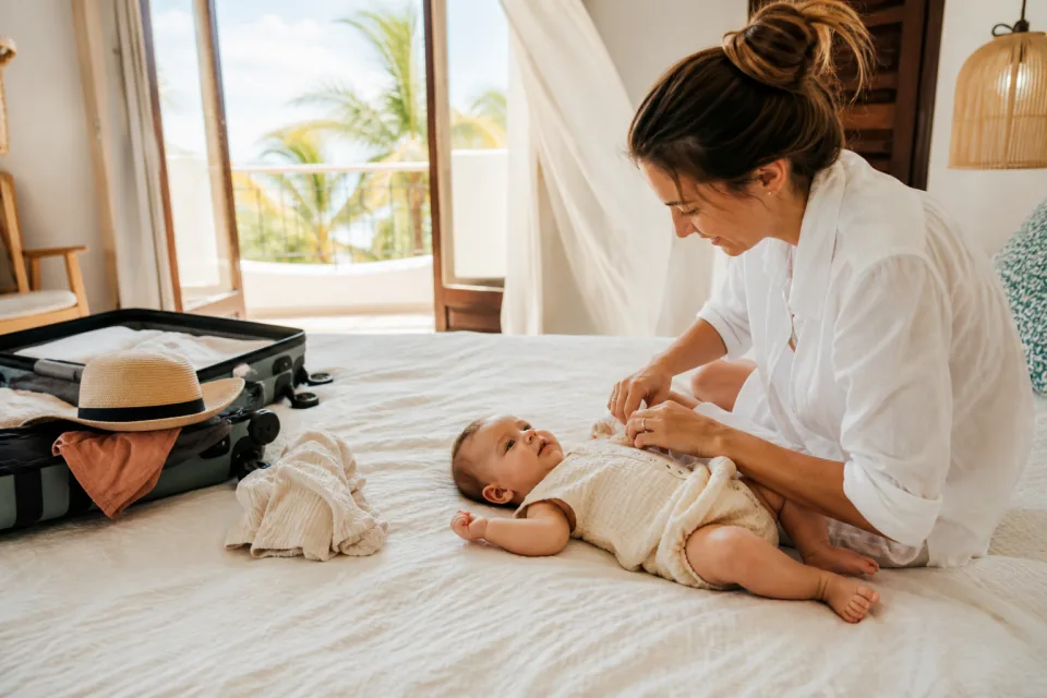A parent changing a baby into one thin muslin romper after arrival